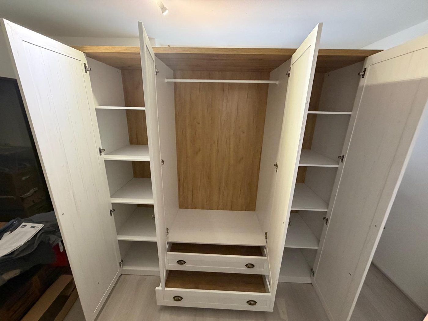 Kleiderschrank mit geöffneten Türen und Schubladen